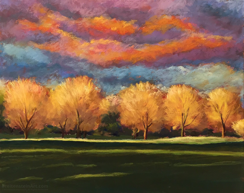 Pastel painting of a row of autumn trees in yellow and orange. There is a sunset above them in orange, purple and blue, and the grass in the foreground is deep in shadow.